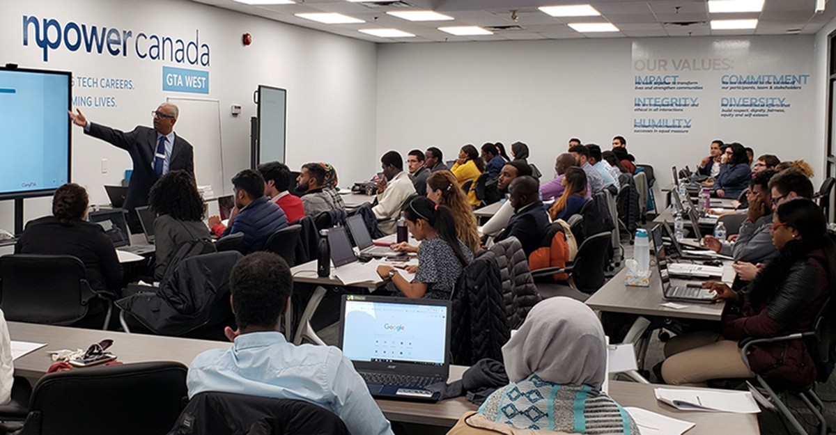 Image d'un groupe d'étudiants en technologie dans une salle de classe écoutant un présentateur de NPower Canada.