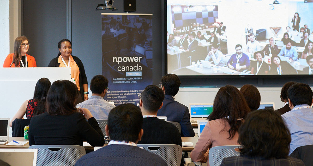 Image d'un groupe d'étudiants en technologie dans une salle de classe écoutant les présentateurs de NPower Canada.