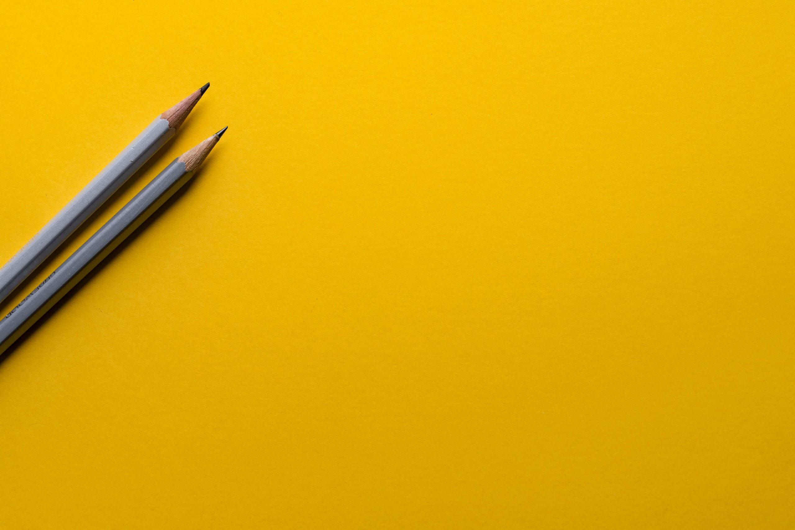 Grey pencils on yellow background